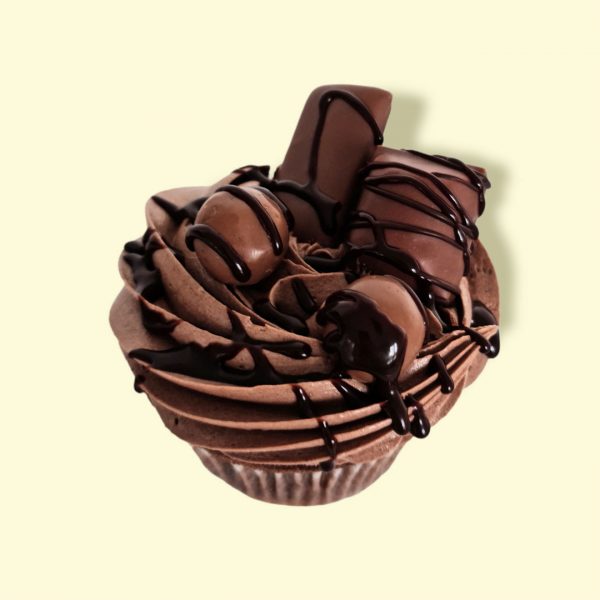 Cupcake gourmand au chocolat avec bonbons en chocolat et sauce chocolat