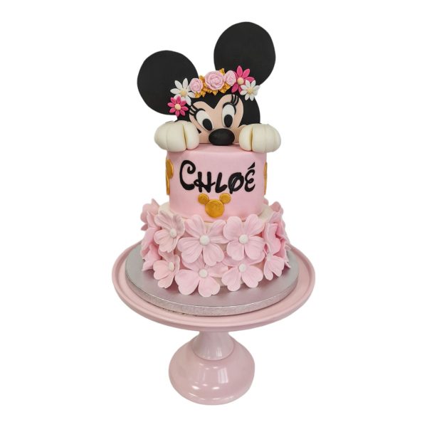 Gâteau à deux étages Minnie Mouse avec une couronne de fleurs et une étage tout en fleurs rose pâle et blanc